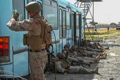 Soldados estadounidenses descansan mientras multitudes esperan poder salir de Afganistán