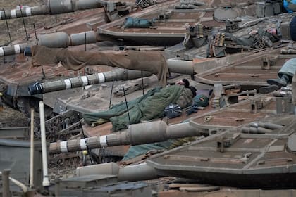 Soldados israelíes duermen en tanques en una zona de preparación en el norte de Israel, en cerca de la frontera con Líbano, el martes 1 de octubre de 2024. (AP Foto/Baz Ratner)