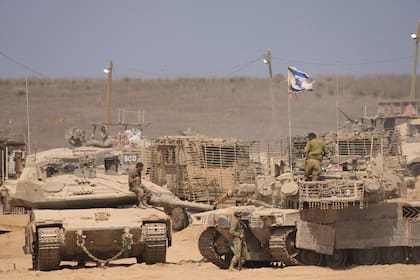 Soldados israelíes trabajan en sus tanques en una zona de preparación en la frontera con la Franja de Gaza, en el sur de Israel, el martes 29 de julio de 2025.