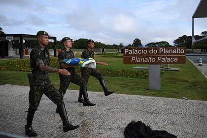 Soldados izan una nueva bandera brasileña en el Palacio Planalto en Brasilia