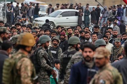 Soldados paramilitares paquistaníes controlan a una multitud cerca del lugar donde explotó una bomba en una mezquita chiíta