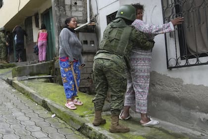 Soldados registran a mujeres mientras patrullan el lado sur de Quito, Ecuador