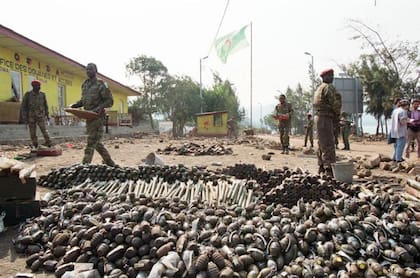 Soldados ruandeses frente a los restos de víctimas del genocidio.