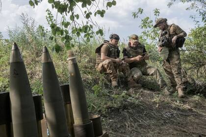 Soldados ucranianos de la 67.a Brigada Mecanizada Separada conversan mientras esperan una llamada de un equipo de drones para disparar morteros hacia las posiciones rusas, cerca de Kreminna, en el este de Ucrania, el 6 de julio de 2023