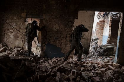 Soldados ucranianos de la 79ª Brigada de Asalto Aéreo avanzando por un edificio dañado en una zona de Marinka, en el este de Ucrania, el 26 de febrero de 2023. 