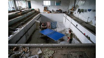 Soldados ucranianos juegan al ping-pong en una piscina dañada en el pueblo de Marinka, cerca de Donetsk, Ucrania oriental
