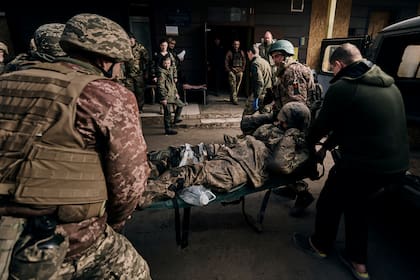 Soldados ucranianos llevan a un colega herido a un hospital en Bakhmut, región de Donetsk, Ucrania
