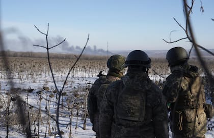 Soldados ucranianos observan una nube de humo durante los combates entre las fuerzas ucranianas y rusas en Soledar, región de Donetsk, Ucrania, miércoles 11 de enero de 2023.