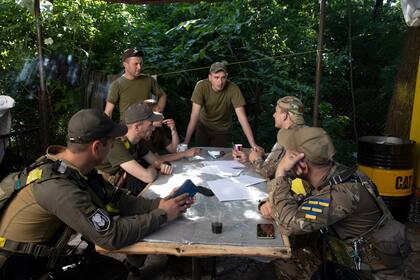Soldados ucranianos se reúnen en una base cerca de su anticuado cañón antitanque justo al noreste de la ciudad de Kherson, Ucrania, ocupada por Rusia, el sábado 4 de junio de 2022.