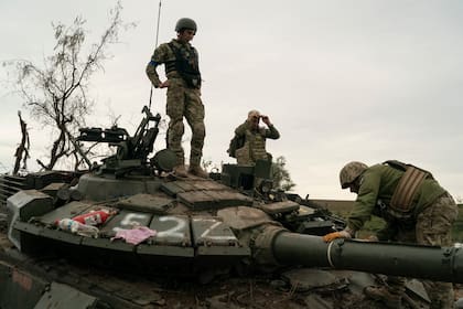 Soldados ucranianos, sobre un tanque ruso destrozado en una zona recuperada cerca de la frontera con Rusia, en la región ucraniana de Kharkiv, el 17 de septiembre de 2022. (AP Foto/Leo Correa)