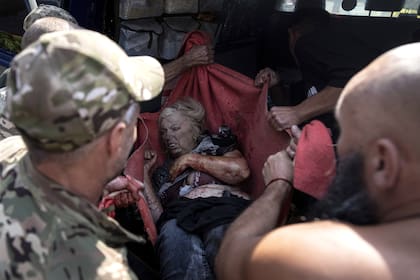 Soldados ucranianos trasladan a una mujer herida a una ambulancia después de un ataque de bombardeo ruso contra el mercado de alimentos en el centro de la ciudad de Kostantínovka, Ucrania, el miércoles 6 de septiembre de 2023. 