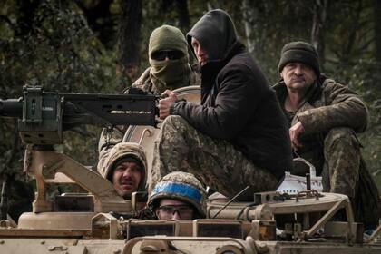 Soldados ucranianos viajan en un vehículo blindado cerca de la ciudad recientemente recuperada de Lyman en la región de Donetsk el 6 de octubre de 2022, en medio de la invasión rusa de Ucrania. (Yasuyoshi CHIBA / AFP)