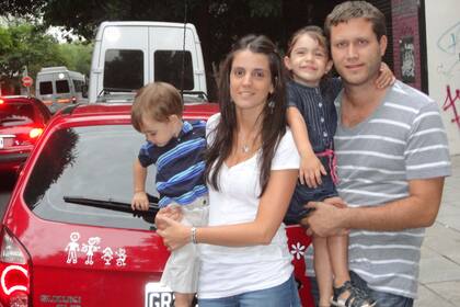 Soledad Diez con su marido, Nicolás, y sus hijos Mia y Thiago; a la izquierda, la familia caracterizada en dibujos sobre el vehículo