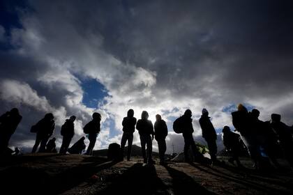 Solicitantes de asilo esperan a ser procesados el viernes 2 de febrero de 2024 en un campamento improvisado cerca de Jacumba Hot Springs, California, luego de cruzar la frontera sur de Estados Unidos. (AP Foto/Gregory Bull)