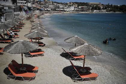Sombrillas en una playa preparada para turistas en Aghia Pelagia, cerca de Heraklion en la isla de Creta