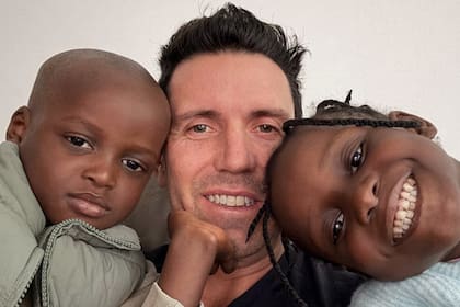 Sonrisas que llenan el alma: Ayson y Milove, de 3 y 5 años, con su papá adoptivo, el extenista Juan Ignacio Chela