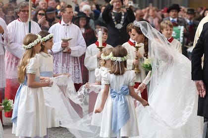 Sophie-Alexandra Evekink, conversando las damitas de honor, vestidas en blanco con fajas celestes de seda. La diseñadora bávara Gabi Nitzl tuvo a su cargo el outfit de los niños, así como también de sus arreglos florales.