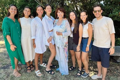 “Soy muy familiera y buena abuela”, dice ella. Acá, posando con sus siete nietos, en una foto que se tomaron el año pasado, cuando cumplió 80. De izquierda a derecha: Solana, Milagros, Trinidad y Carmela (son las hijas de Nachi) y
Estefanía, Pilar y Federico (son hijos de Lorena)