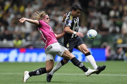 Spinelli, que jugó en numerosos clubes de Argentina y de otros países a pesar de tener 28 años, obstruye a Junior Alonso; el ex defensor paraguayo de Boca hizo la asistencia para el tercer y decisivo tanto de Mineiro.