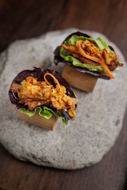 Ssam de chivo mendocino en hojas de lechuga, con coleslaw, granola spicy y mermelada de cebolla