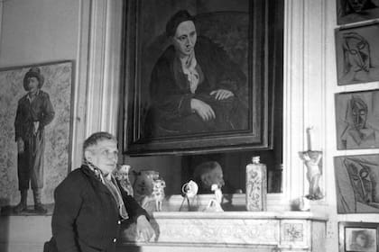 Stein posa, en su departamento parisino, frente al retrato que le hizo Picasso en 1906


