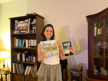 Stella posando junto a dos ejemplares de los libros que escribió.