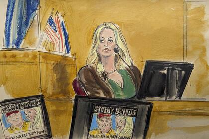 Stormy Daniels testifies on the witness stand as a promotional image for one of her shows featuring an image of Trump is displayed on monitors in Manhattan criminal court.