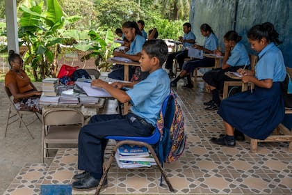 Students during classes in the village of Limon, Panama, on July 10, 2024. Teachers worry that displacement by a Río Indio dam could upturn the lives of children, some of whom depend on the school kitchen for meals. (Federico Rios/The New York Times)