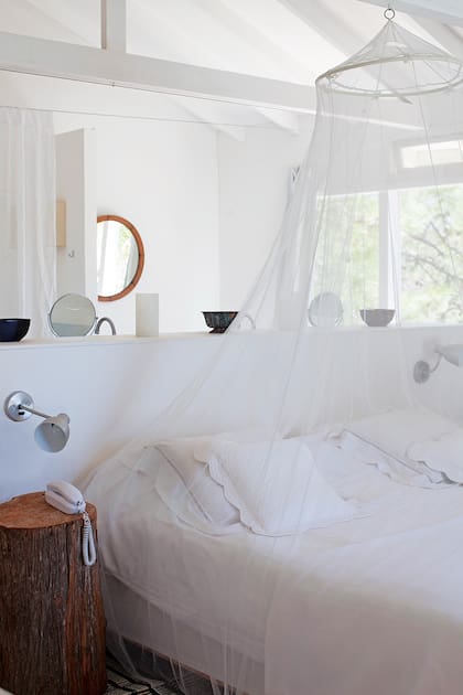 Su habitación, blanca, con pocos muebles y toques rústicos, resulta perfecta para una casa de verano.