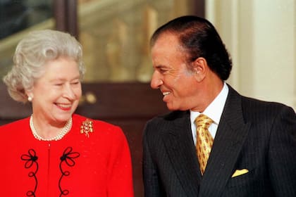 Su majestad la reina Isabel II y el expresidente Carlos Menem sonrien durante el encuentro en el Palacio de Buckingham, donde el jefe de estado argentino fue agasajado con un almuerzo en su honor, el 28 de noviembre de 1998