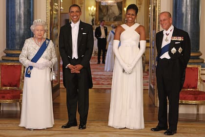 Su Majestad posa junto a Barack Obama –en ese momento presidente de Estados Unidos–, su mujer, Michelle Obama, y el duque de Edimburgo, en la sala de música del Palacio de Buckingham, tras el banquete de Estado con el que la pareja real homenajeó a sus visitantes, en mayo de 2011.

