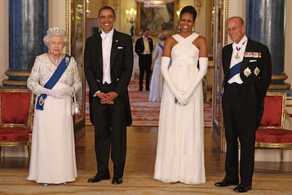 Su Majestad posa junto a Barack Obama –en ese momento presidente de Estados Unidos–, su mujer, Michelle Obama, y el duque de Edimburgo, en la sala de música del Palacio de Buckingham, tras el banquete de Estado con el que la pareja real homenajeó a sus visitantes, en mayo de 2011.
