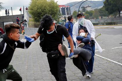 Paramédicos se llevan a un manifestante herido durante enfrentamientos con la policía, cerca de la Asamblea Nacional, en Quito