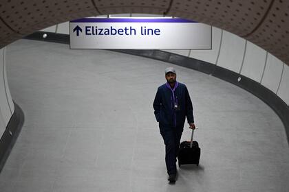 Un trabajador camina a través de un túnel en la estación de Liverpool Street durante una prueba de un tren de la línea Elizabeth de Transport for London (TfL) entre la estación de Paddington y la estación de Liverpool Street, en Londres el 11 de mayo de 2022. 