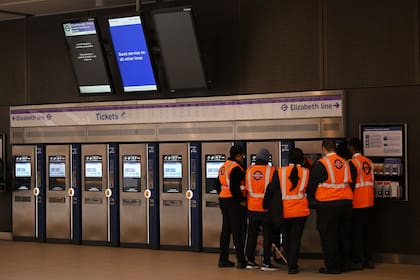 Los trabajadores se apiñan cerca de las máquinas expendedoras de billetes en la estación de Paddington durante un recorrido de prueba de un tren de la línea Elizabeth de Transport for London (TfL), entre la estación de Paddington y la estación de Liverpool Street, en Londres el 11 de mayo de 2022.