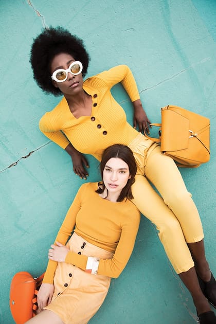 Suéter con botones y anteojos blancos (Las Pepas), pantalón (Mirta Armesto) y mochila de cuero (Blaquè). Suéter liso (Paula Cahen D’Anvers), minifalda con botones de corderoy y pulseras (Las Pepas), mochila y zapatillas de cuero (Blaquè)