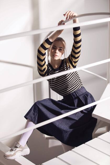 Falda de jean con cinturón (Tommy Hilfiger), suéter de lúrex y zapatillas con abrojos (Vitamina).