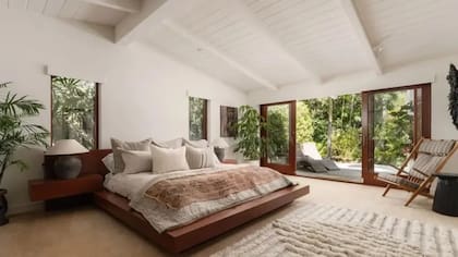 Suite principal con techo de madera a la vista, grandes superficies vidriadas y disposición estratégica para maximizar la luz natural y las vistas al parque