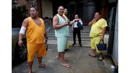 El luchador Kyokutaisei, Kyokushuho de origen mongol y los brasileros Kaisei y Asahisho, se preparan para abandonar el templo Ganjoji Yakushido para una cena que se celebrará en Nagoya