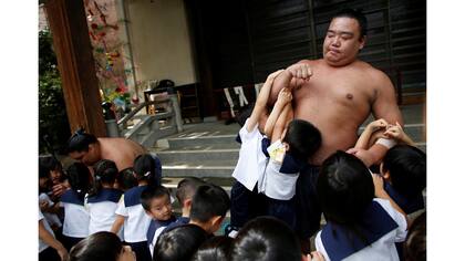 El luchador de sumo Kainoryu juega con los niños de un jardín de infantes