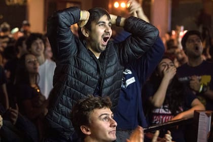 Fanáticos de los New England Patriots alientan desde los bares en los alrededores del US Bank Stadium en Minneapolis, Minnesota