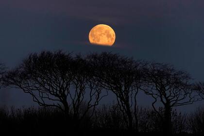 La luna durante el amanecer en luna se Whitley Bay, en el noreste de Inglaterra