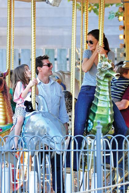 Suri, Tom Cruise y Katie Holmes se divierten en una calesita en Pittsburgh, Pennsylvania, en octubre de 2011.