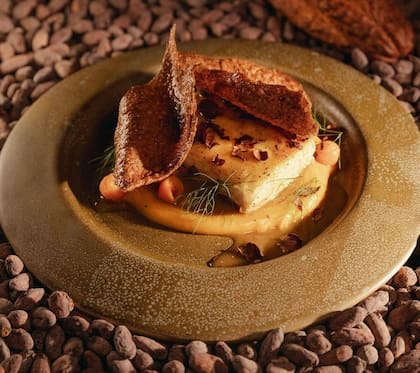 Surubí pochado en gastrique de limón negro, puré de boniato y cascarilla frita.