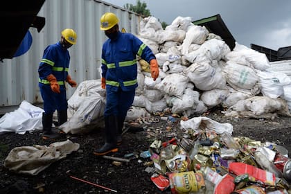 Tabajadores nepalíes arrastran bolsas de basura recolectadas del Monte Everest para reciclarlas, en Katmandú