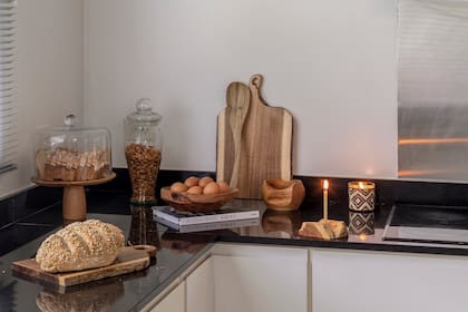 Tablas (Mekk Home) velas de tejido mbeya y madera tallada (Artisan) y cuencos de madera tallados.