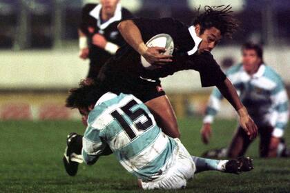 Tana Umaga, de All Blacks, encara al fullback argentino Ezequiel Jurado en el Rugby Park, en Hamilton, en 1997.