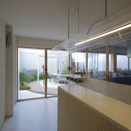 Tanto la barra como el cuerpo del cerramiento de la cocina están revestidos con yeso, con una trama a rayas hecha a mano.