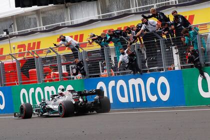 Tarea cumplida: Lewis Hamilton cruza la meta en el Gran Ptremio de Hungría y los mecánicos festejan desde el enrejado el éxito del piloto británico