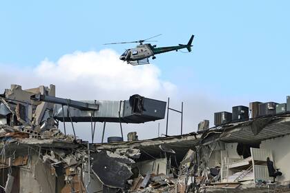 Un helicóptero sobrevuela la zona donde colapsó la torre de condominios